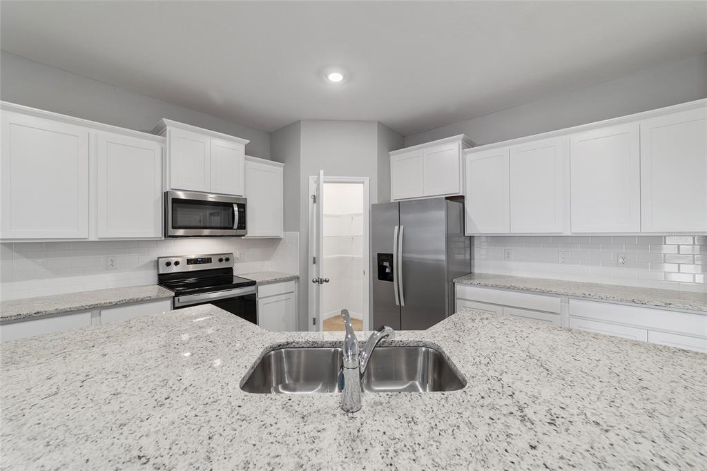 5339 Northwest 46th Ln Road Ocala, FL 34482 - Photo 19 of 79 a kitchen with stainless steel appliances a refrigerator a sink a stove a microwave and cabinets