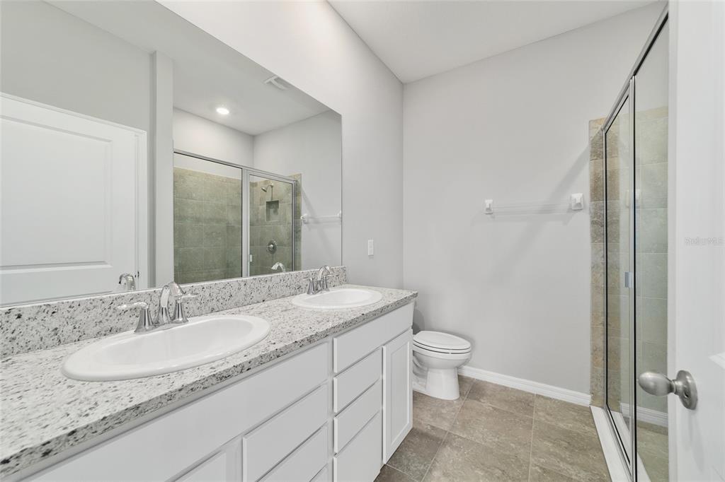 5339 Northwest 46th Ln Road Ocala, FL 34482 - Photo 28 of 79 a bathroom with a granite countertop sink a mirror and a toilet