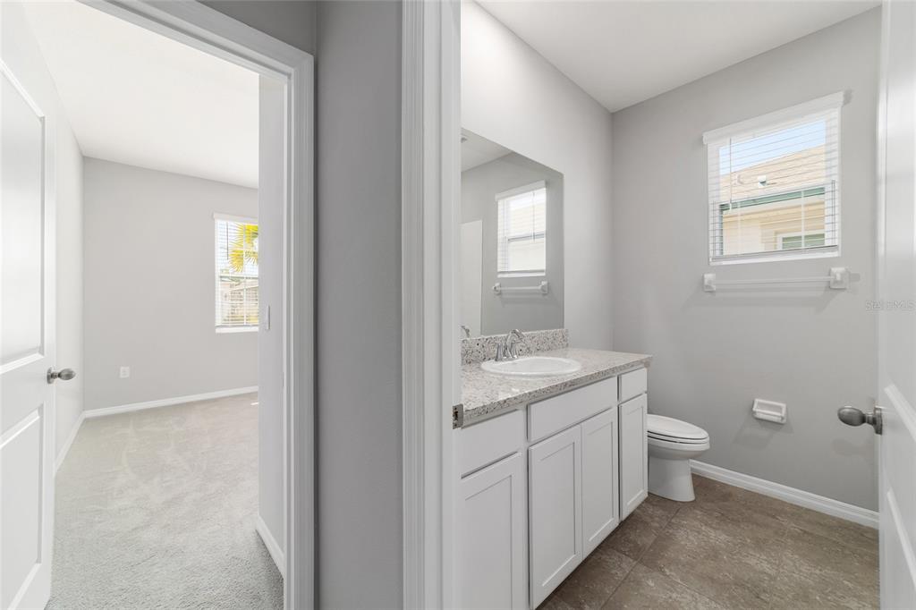 5339 Northwest 46th Ln Road Ocala, FL 34482 - Photo 33 of 79 a bathroom with a granite countertop toilet a sink and a mirror