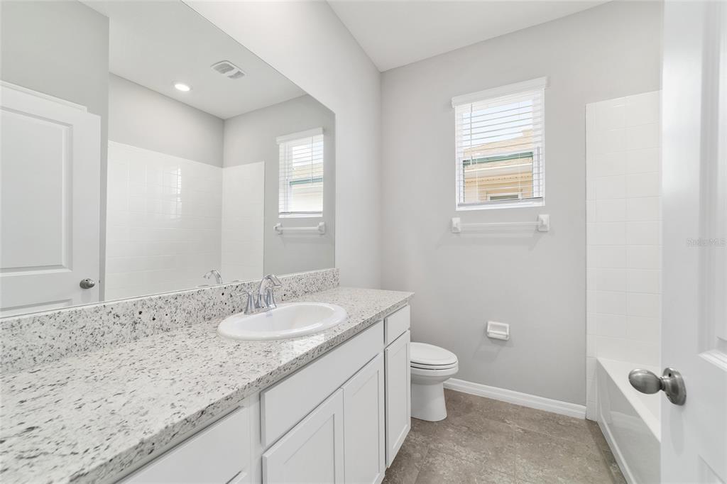 5339 Northwest 46th Ln Road Ocala, FL 34482 - Photo 34 of 79 a bathroom with a granite countertop sink a toilet and a mirror
