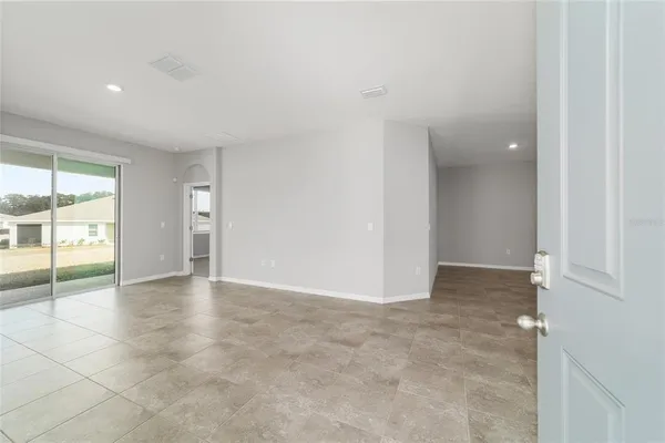 an empty room with chandelier and windows