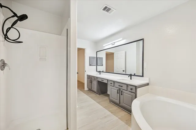 a bathroom with a tub sink and mirror