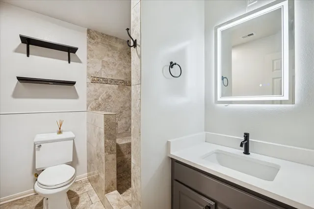 a bathroom with a sink a toilet and shower