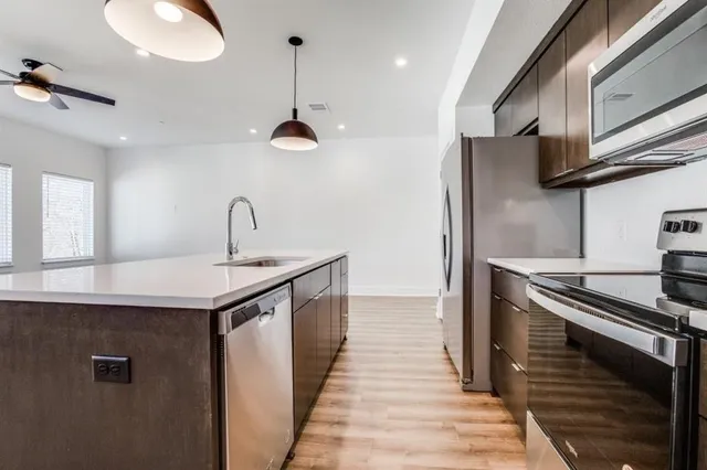 a kitchen with stainless steel appliances granite countertop a sink and a refrigerator