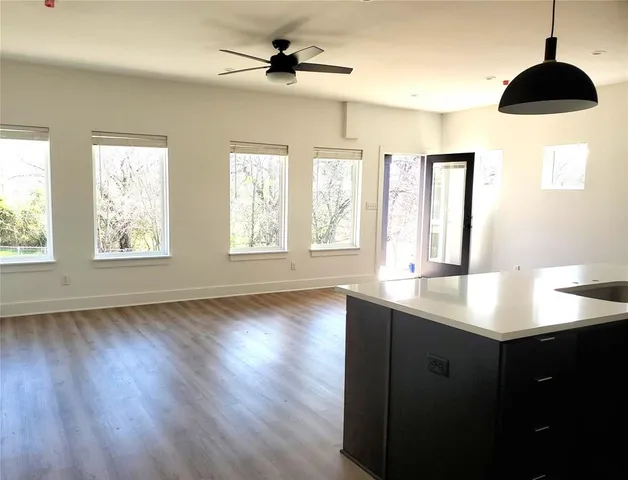 a kitchen with stainless steel appliances a sink a window and wooden floor