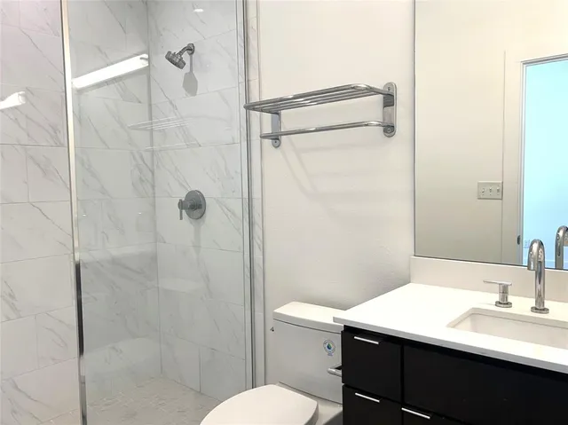a bathroom with a sink toilet vanity and shower