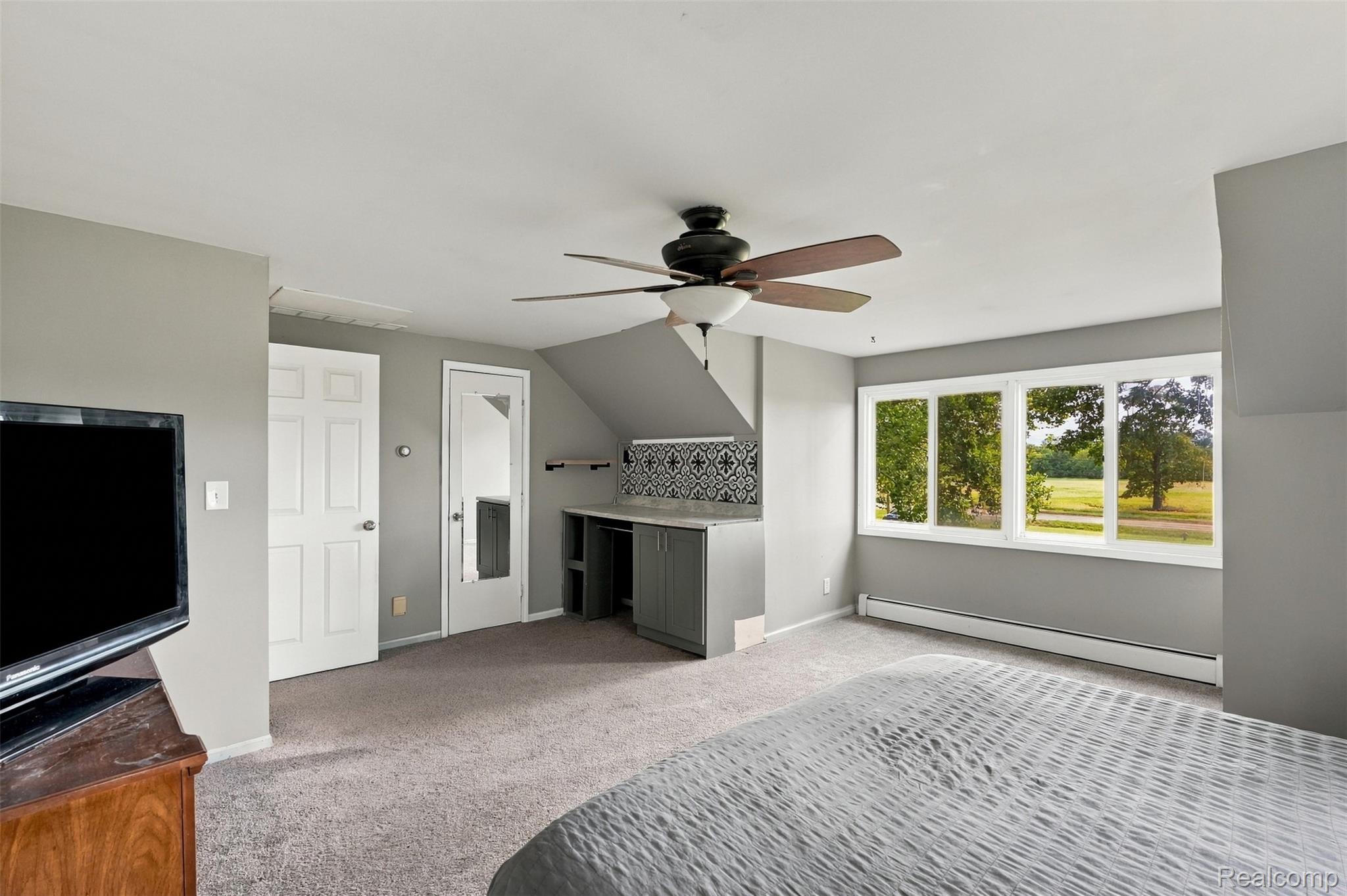 26516 Romine Road New Boston, MI 48164 - Photo 24 of 62 Built-in desk with patterned tile backsplash, multi-pane windows, and a ceiling fan with integrated lighting