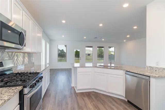a large kitchen with stainless steel appliances granite countertop a stove and a sink
