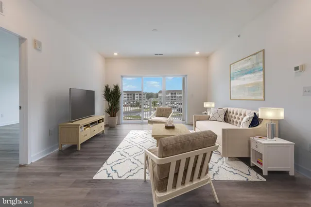 a living room with furniture flat screen tv and a large window