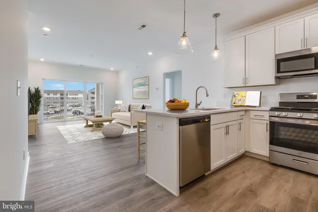 a kitchen that has a lot of cabinets a sink and appliances in it
