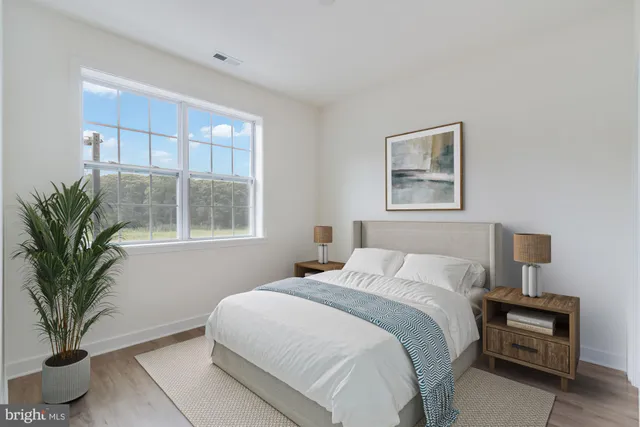a bedroom with a large bed and a potted plant
