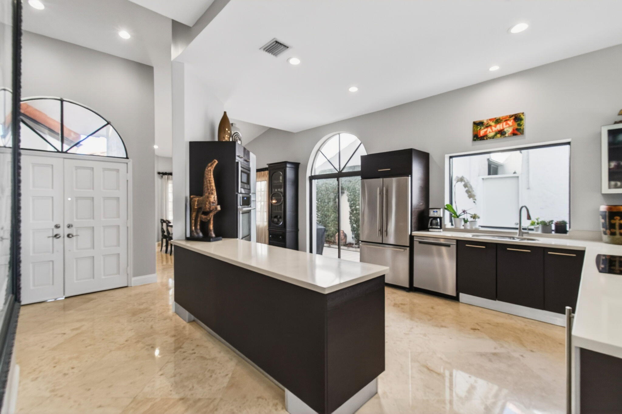 23145 Via Stel Boca Raton, FL 33433 - Photo 15 of 72 a large kitchen with kitchen island a large counter top space a sink stainless steel appliances and cabinets