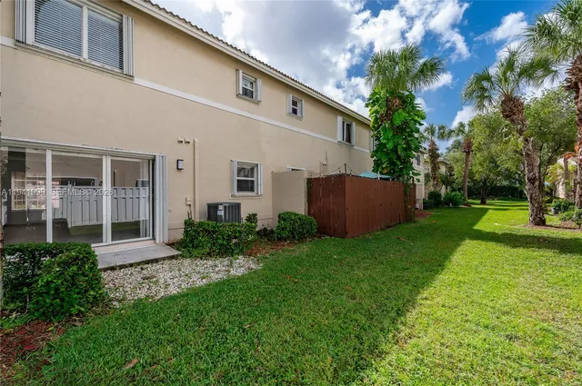 a view of backyard with potted plants and a large tree