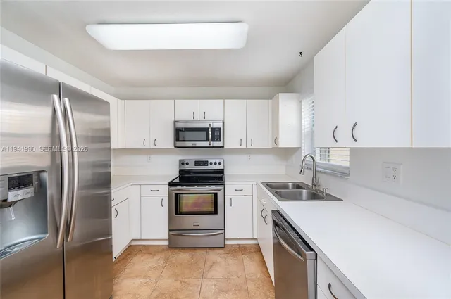 a kitchen with stainless steel appliances cabinets a sink and a stove