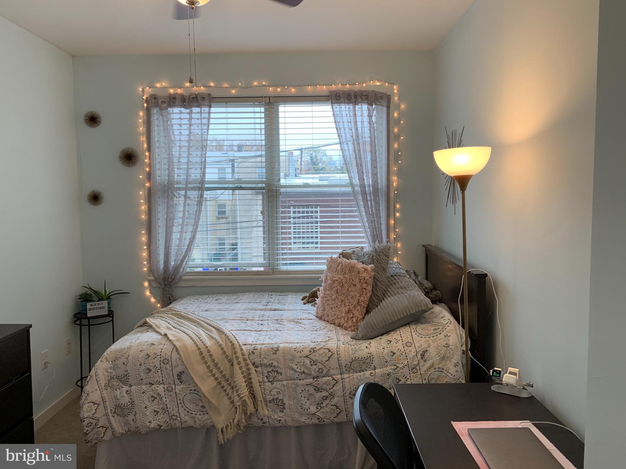 a bedroom with a bed and a lamp next to a window