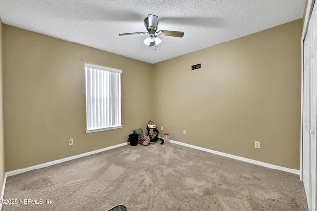 a view of a room with window and a ceiling fan