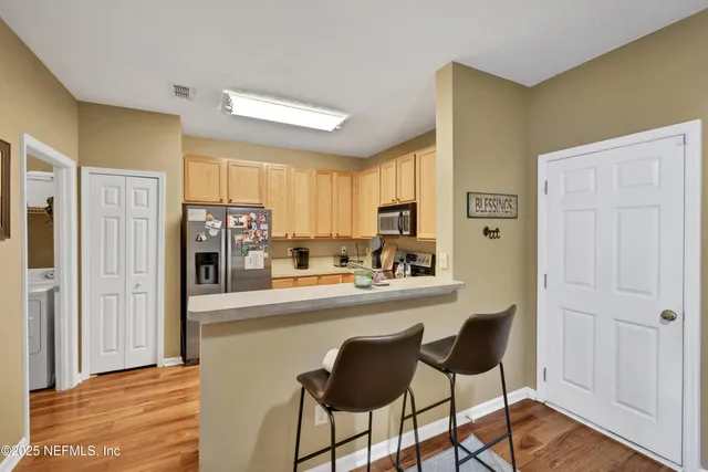 a kitchen with stainless steel appliances granite countertop a refrigerator and a stove top oven