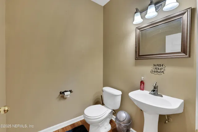 a bathroom with a toilet a sink and a mirror