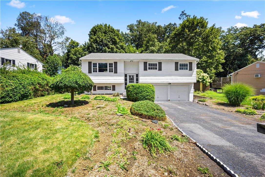 a front view of a house with a yard and trees