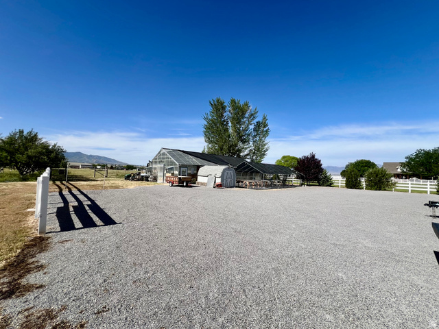 812 East Bates Cyn Road Tooele, UT 84074 - Photo 105 of 144 Expansive gravel lot featuring a large greenhouse structure with a clear roof and dark siding