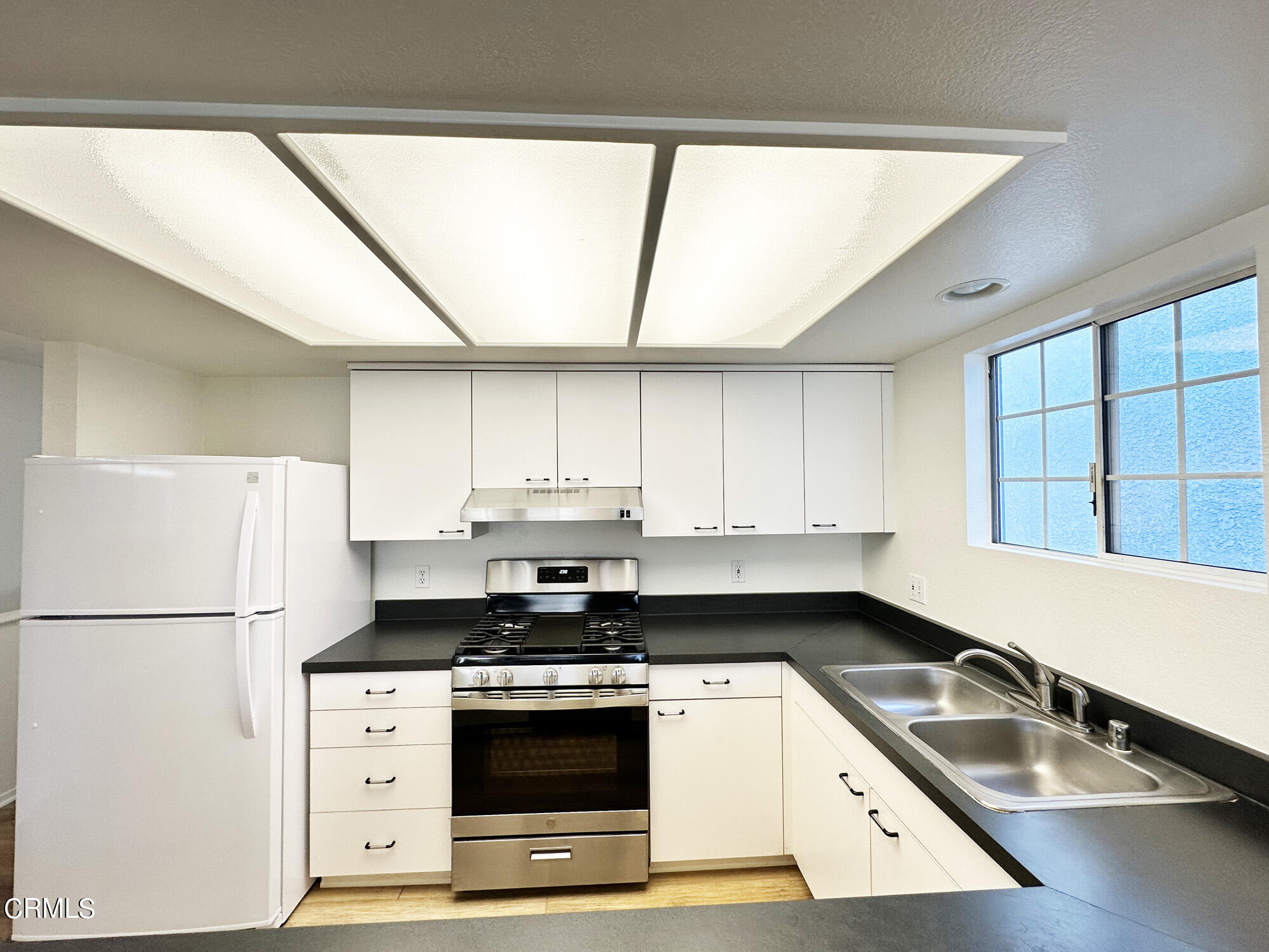 356 Highland Drive Oxnard, CA 93035 - Photo 7 of 26 a kitchen with a refrigerator a sink and a window