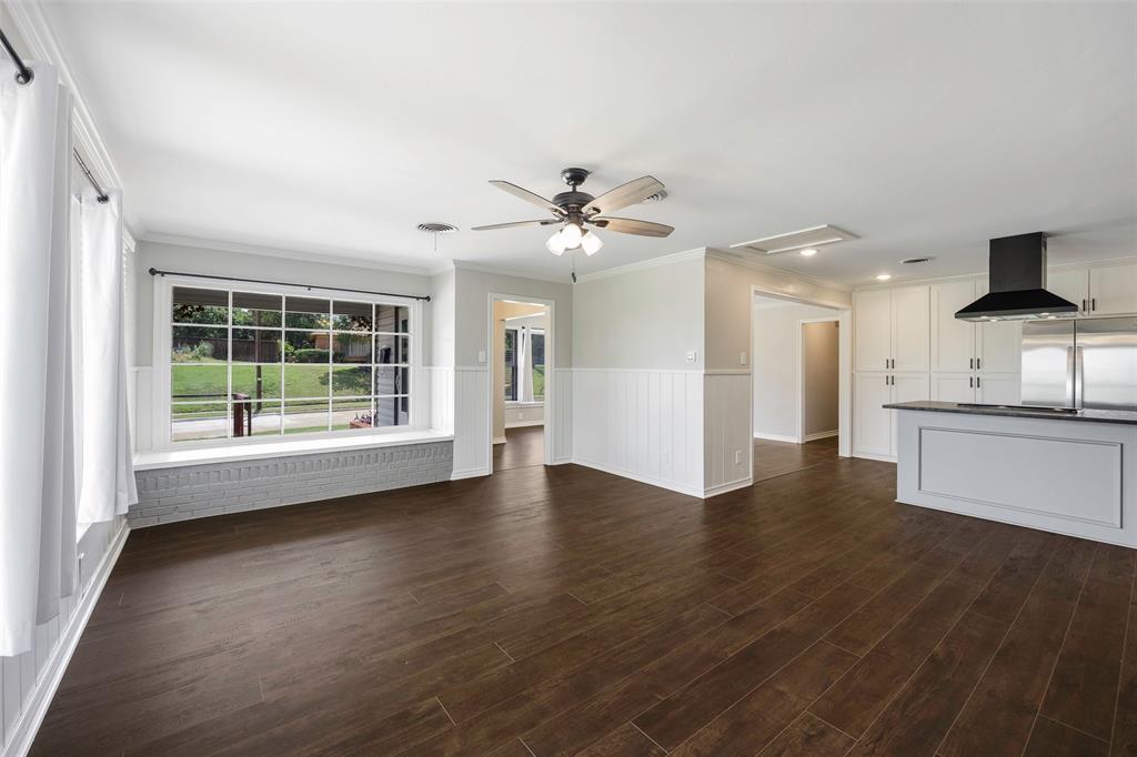 2323 Sutter Street Dallas, TX 75216 - Photo 13 of 30 Unfurnished family room featuring crown molding, dark wood-type flooring, and ceiling fan