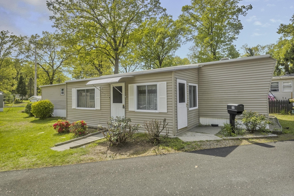 a front view of a house with a yard and outdoor seating