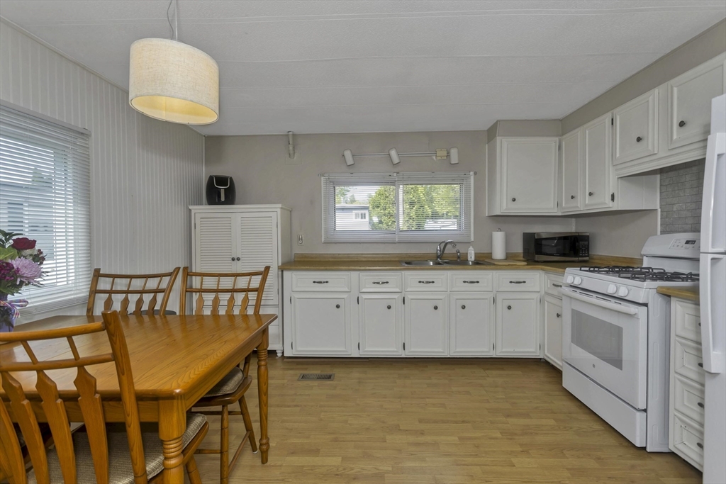 32 Puffin Drive Chicopee, MA 01020 - Photo 2 of 25 a kitchen with granite countertop a stove a sink a dining table and chairs