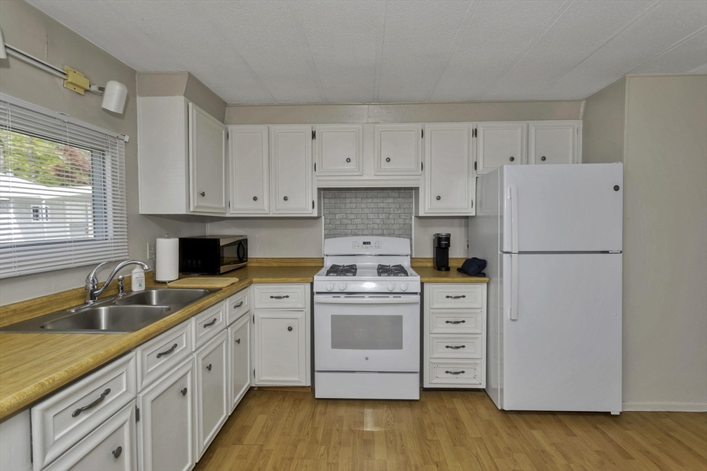 32 Puffin Drive Chicopee, MA 01020 - Photo 3 of 25 a kitchen with white cabinets and white appliances