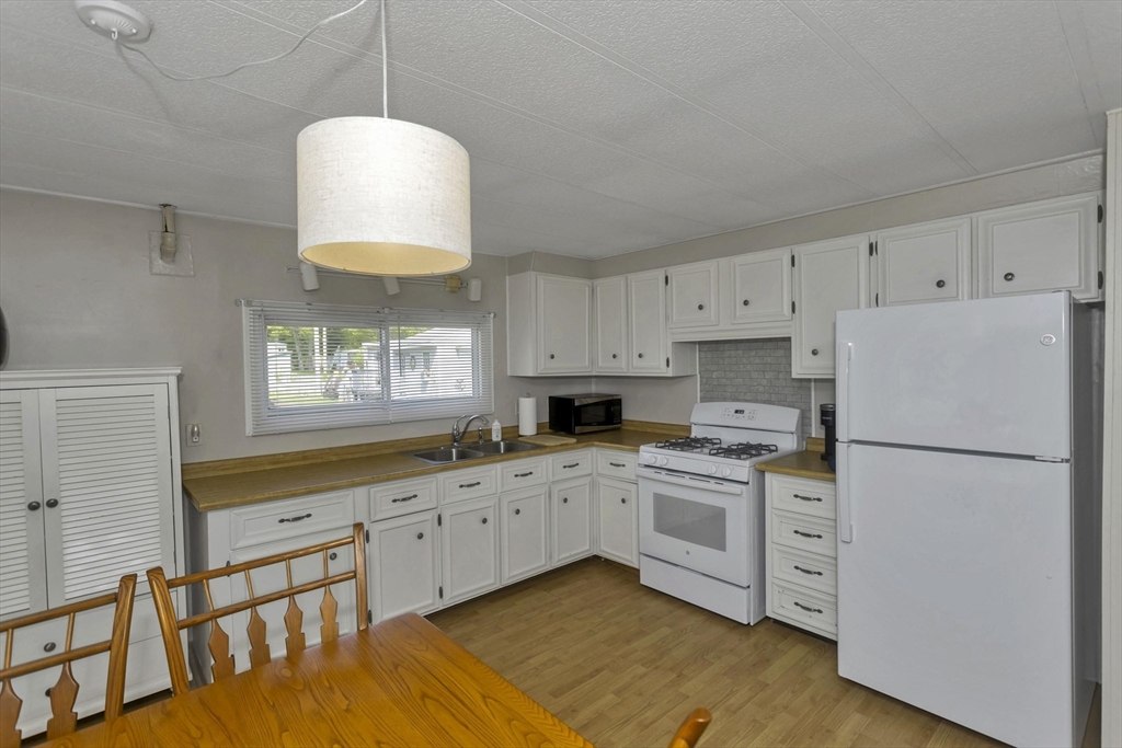 32 Puffin Drive Chicopee, MA 01020 - Photo 5 of 25 a kitchen with white cabinets and white appliances