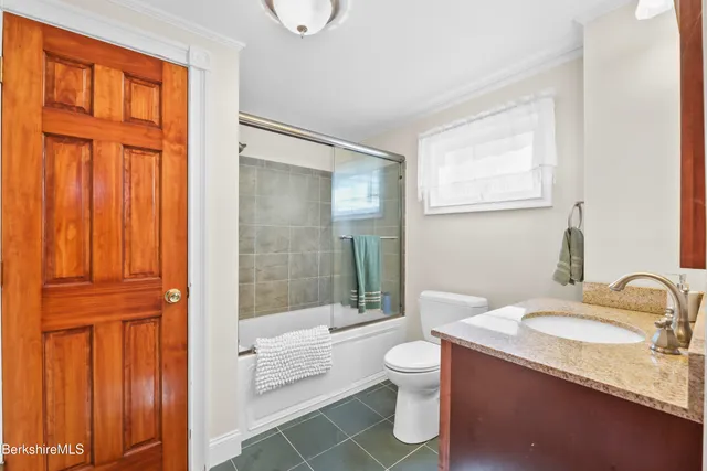 a bathroom with a granite countertop sink toilet and shower