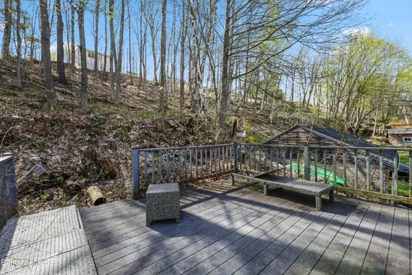 a view of a patio with couches table and chairs with wooden floor and fence