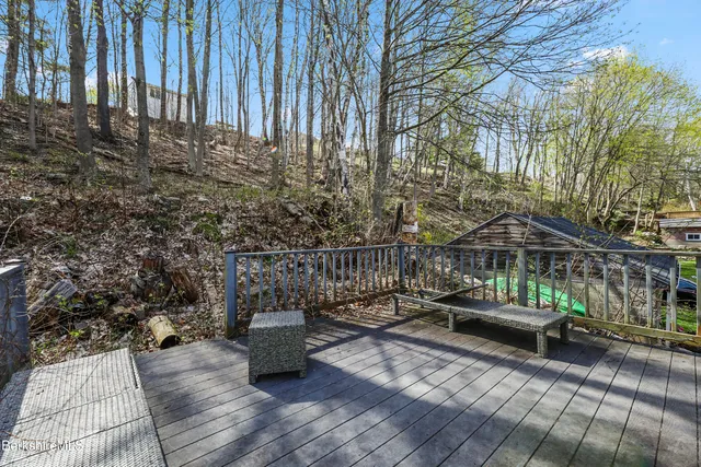 a view of a patio with couches table and chairs with wooden floor and fence