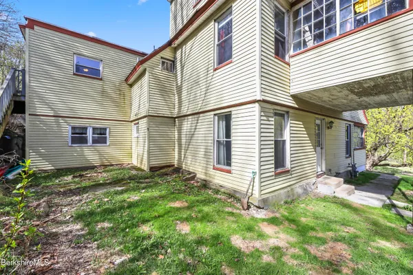 a view of a house with a yard and sitting area