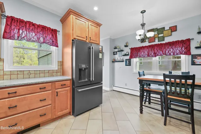 a kitchen with granite countertop a refrigerator and a stove top oven