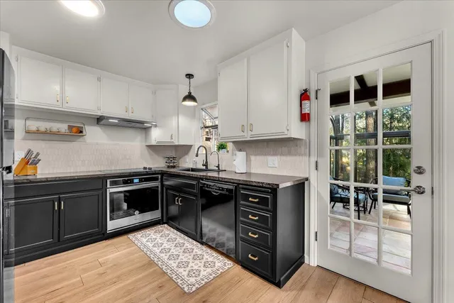 a kitchen with stainless steel appliances granite countertop a stove and a sink