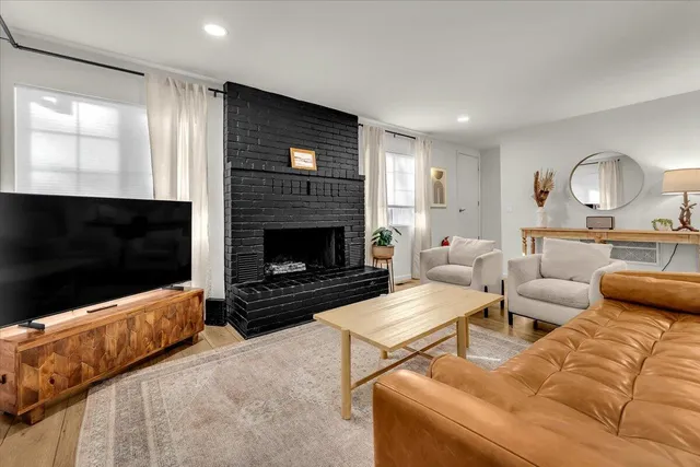 a living room with furniture a flat screen tv and a fireplace