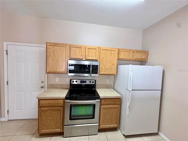 a kitchen with stainless steel appliances a refrigerator stove and microwave