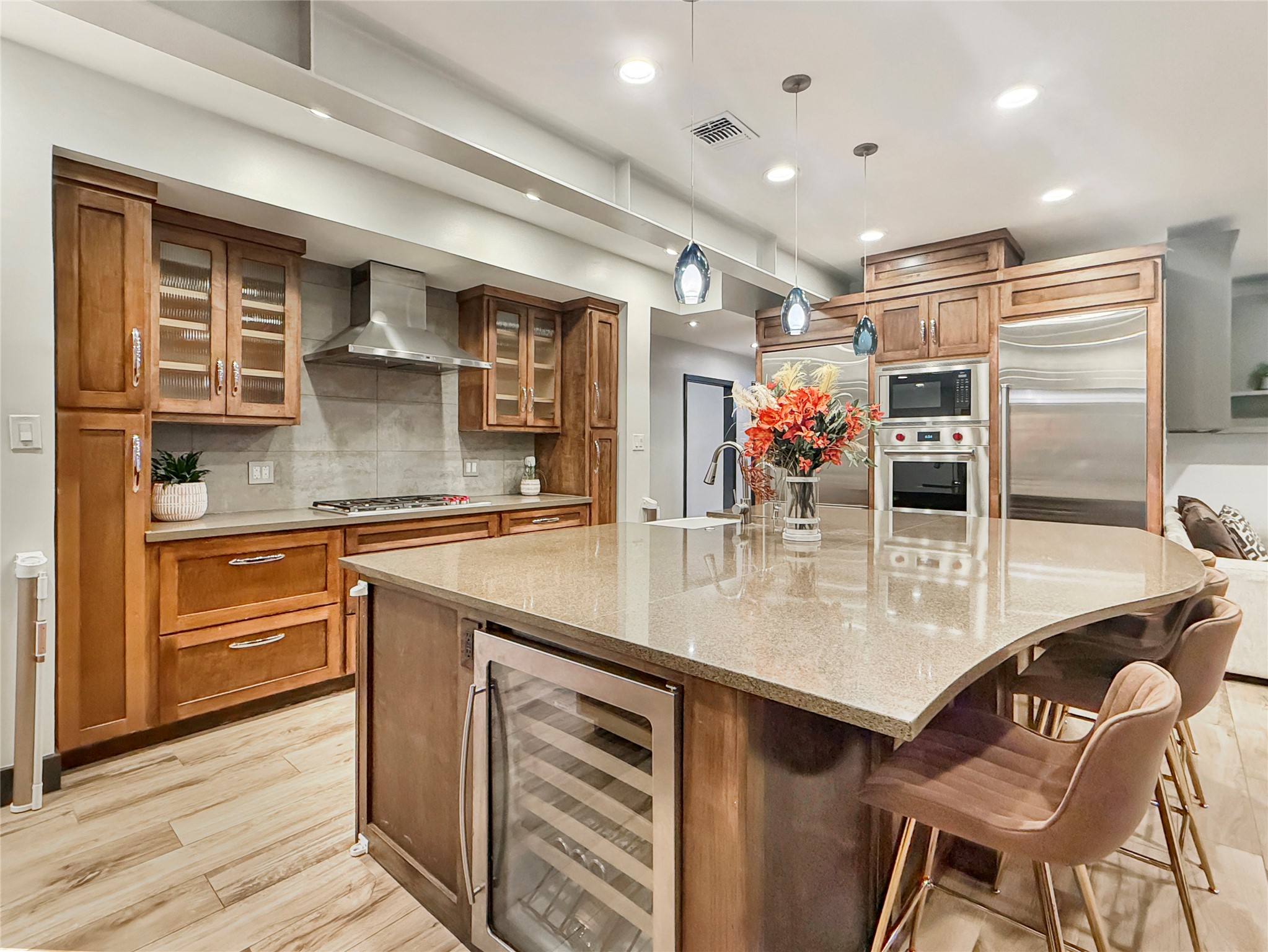 4521 Maple Street Bellaire, TX 77401 - Photo 12 of 36 Entertainer’s island featuring built-in wine cooler, and seating, positioned for seamless hosting.