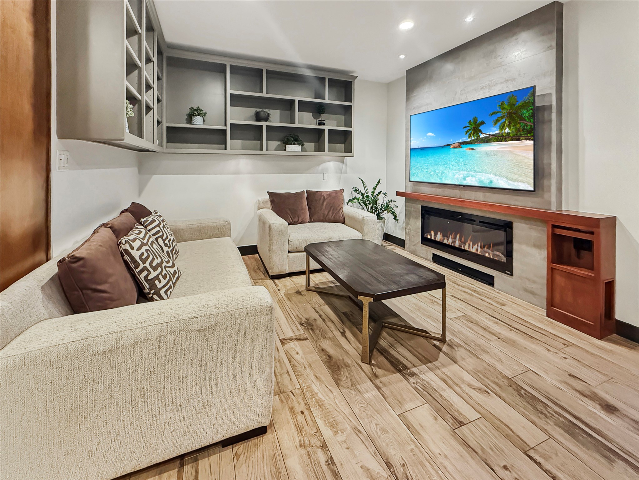 4521 Maple Street Bellaire, TX 77401 - Photo 17 of 36 Alternate view highlighting the integrated media wall, recessed lighting, and generous wall space for oversized art or television. Built-in cabinetry provides both display and hidden storage.