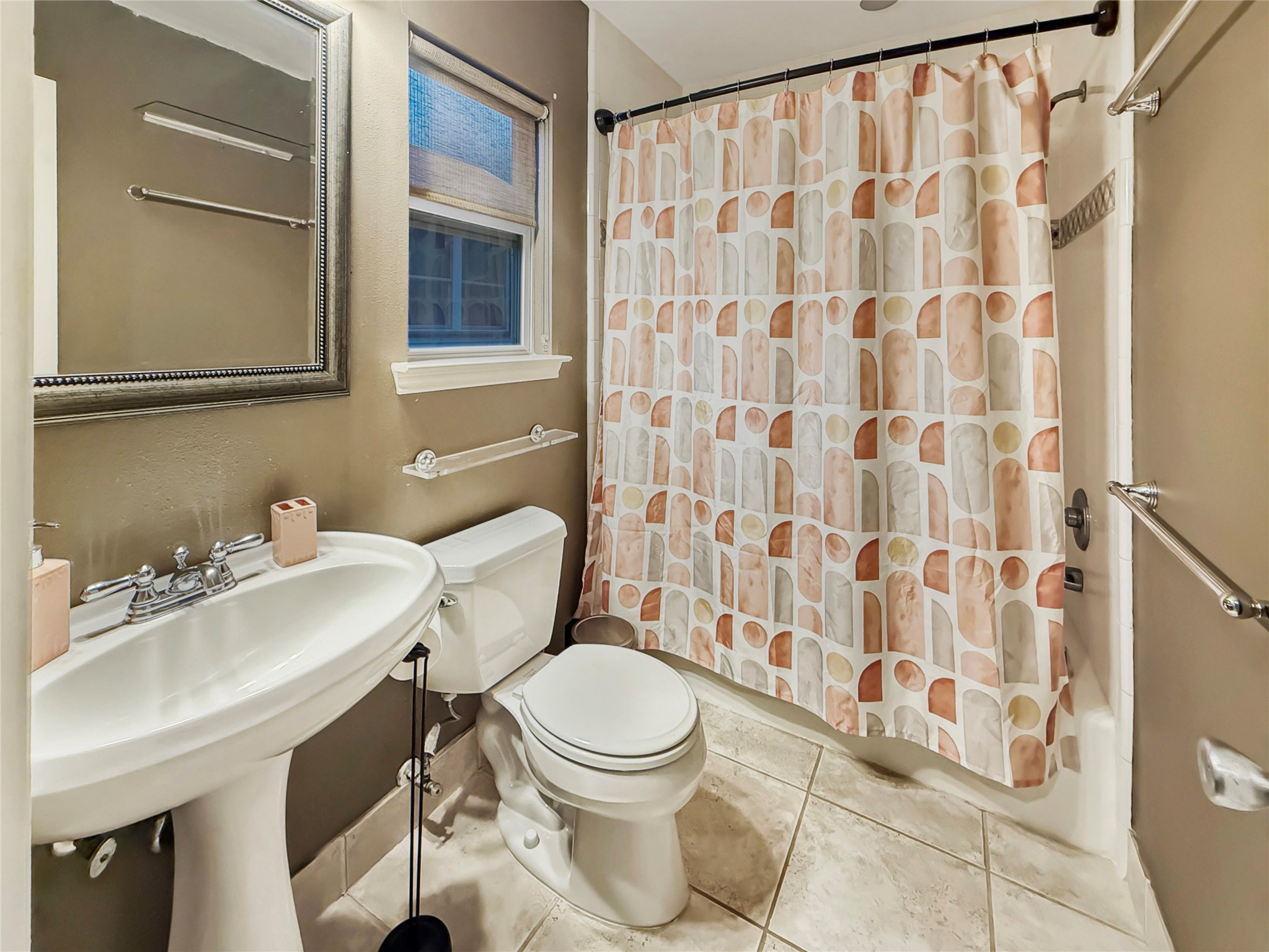 4521 Maple Street Bellaire, TX 77401 - Photo 33 of 36 Bright full bath with pedestal vanity, neutral finishes, and shower/tub combination.