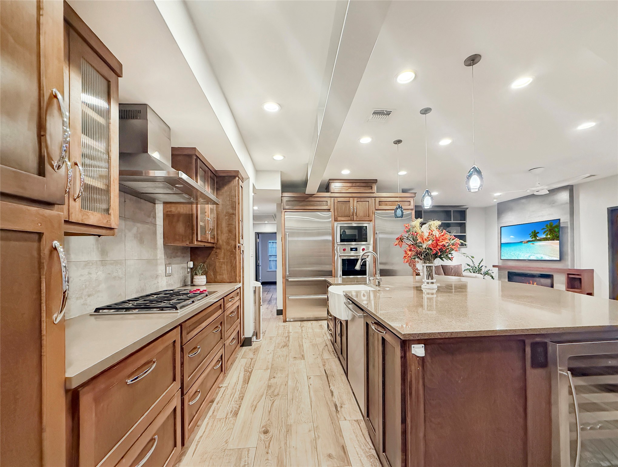 4521 Maple Street Bellaire, TX 77401 - Photo 9 of 36 Chef’s kitchen designed to impress, featuring Wolf gas cooktop, Sub-Zero refrigerator and separate freezer, oversized island with seating, farmhouse sink, and extensive custom cabinetry.