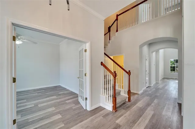 a large white kitchen with kitchen island a sink dishwasher a refrigerator and white cabinets with wooden floor