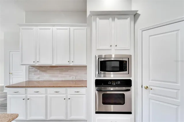 an empty room with a ceiling fan and windows