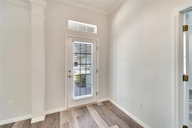 a view of a room with wooden floor stairs and a chandelier