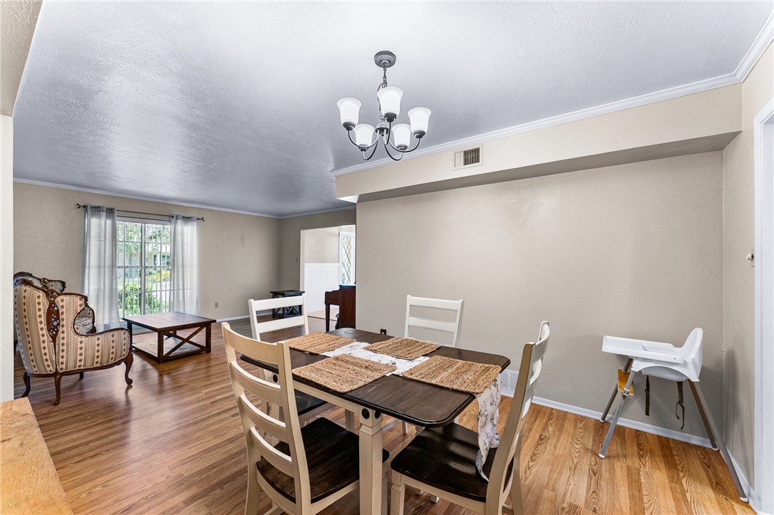 4325 St George Drive Corpus Christi, TX 78413 - Photo 11 of 22 a view of a dining room with furniture a chandelier and wooden floor