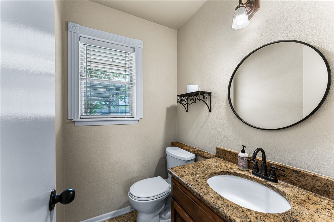 4325 St George Drive Corpus Christi, TX 78413 - Photo 17 of 22 a bathroom with a granite countertop toilet a sink and a mirror