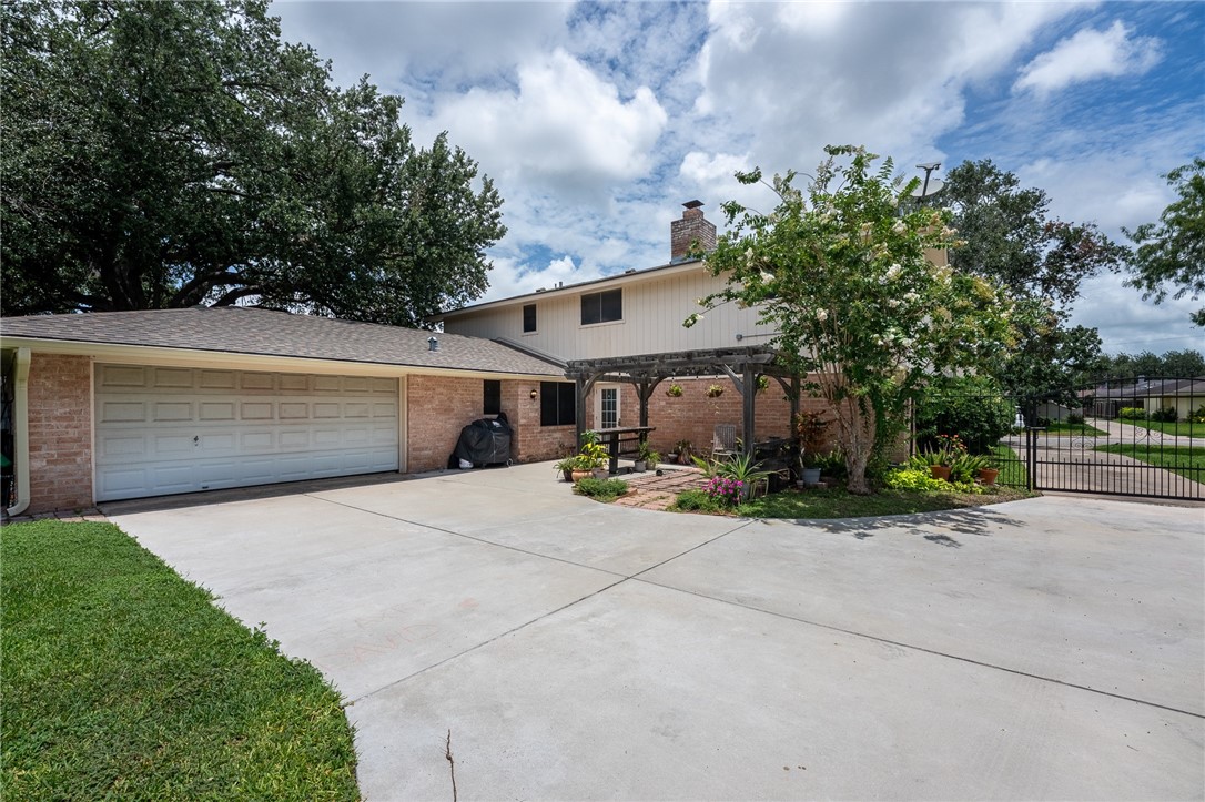 4325 St George Drive Corpus Christi, TX 78413 - Photo 3 of 22 a front view of a house with a yard and garage