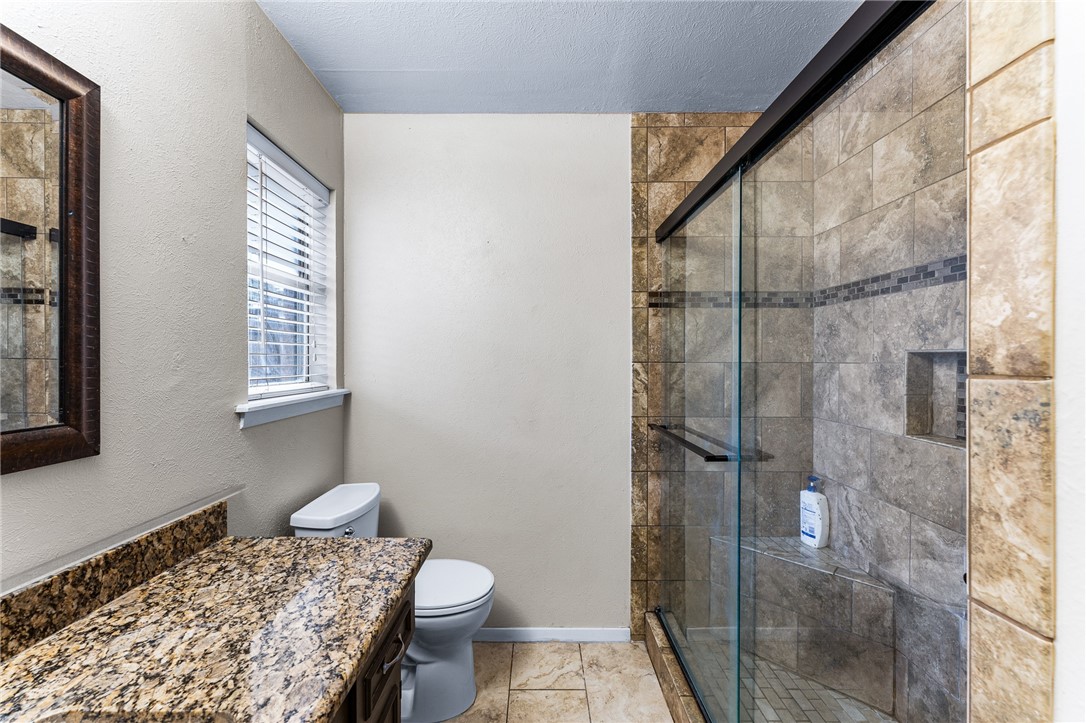 4325 St George Drive Corpus Christi, TX 78413 - Photo 8 of 22 a bathroom with a granite countertop sink toilet and shower