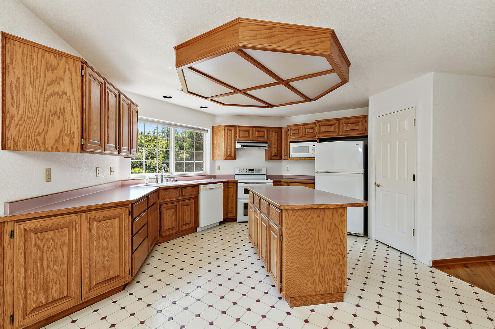 7212 Lower River Road Grants Pass, OR 97526 - Photo 12 of 31 a kitchen with stainless steel appliances a sink a stove a refrigerator cabinets and a window